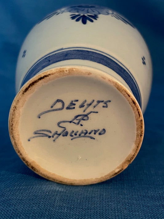 Dit Delftsblauw vaasje is aan de onderzijde gesigneerd.