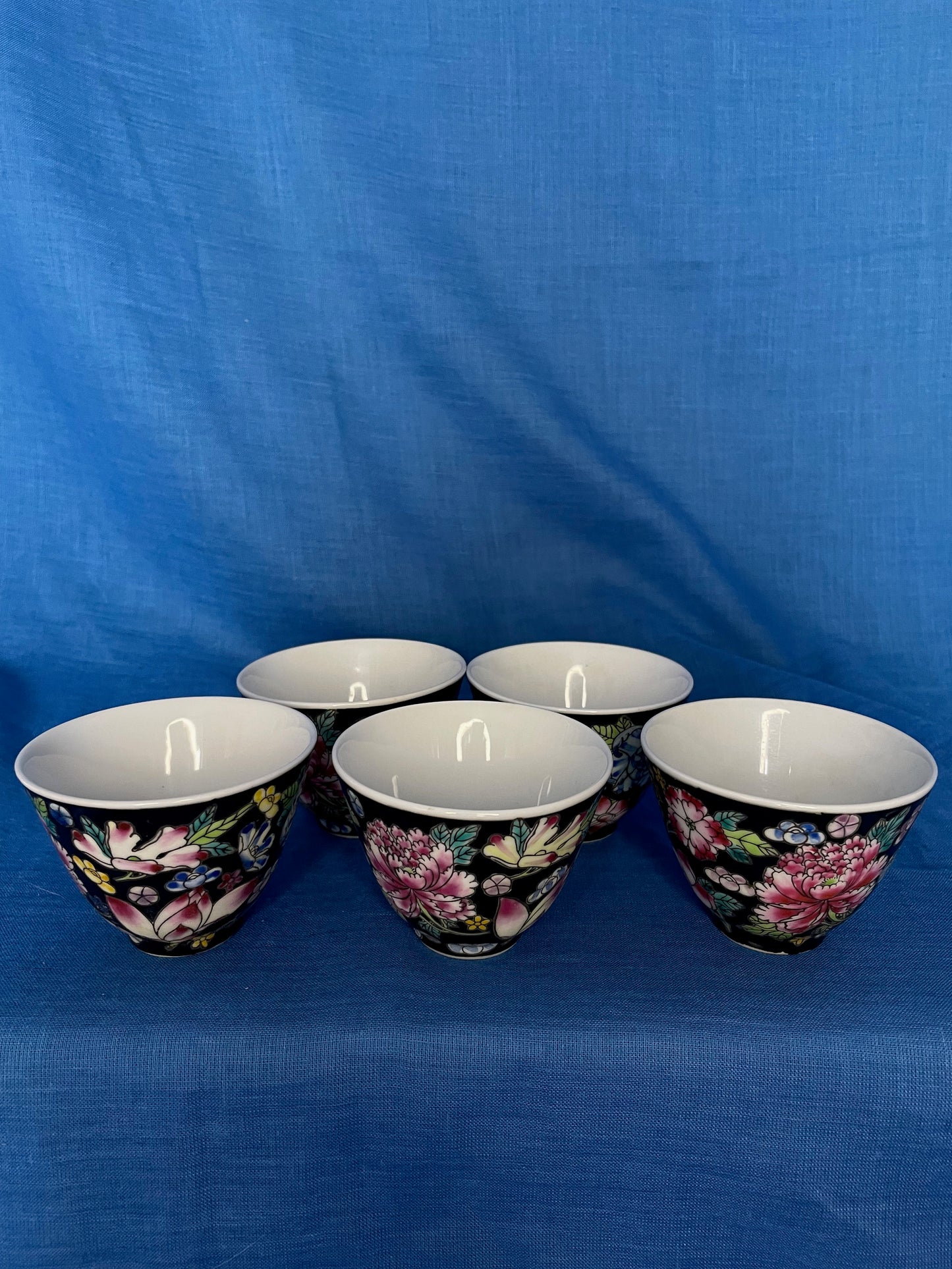 Chinese set van kommetjes met mooie bloemen op een donkere achtergrond